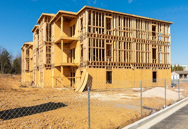 a close-up of temporary chain link fences enclosing a job site, signaling progress in the project's development in Rimforest, CA